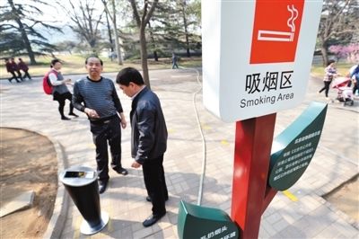 月1日,北京动物园,两位游客在吸烟区抽烟。“京版”控烟条例草案拟规定室内公共场所全面禁烟。新京报记者 薛珺 摄