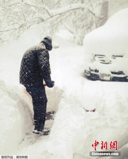 资料图:当地时间11月18日,美国东北部地区遭遇大雪袭击,纽约州气温聚降,伊利湖出现大湖效应。图为纽约市民在清除积雪。